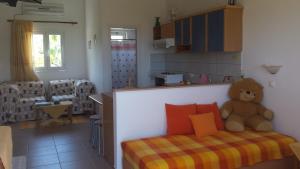 a teddy bear sitting on a bed in a room at Galini Apartments in Palekastron