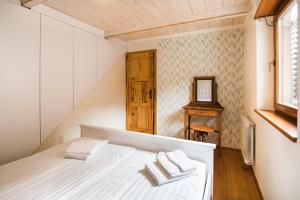Schlafzimmer mit einem weißen Bett und einem Spiegel in der Unterkunft Apartma Lojz in Bovec