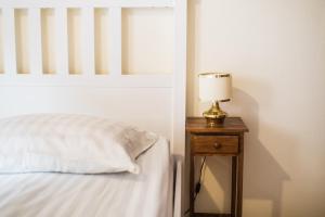 a bed with a lamp on a wooden night stand at Apartma Lojz in Bovec