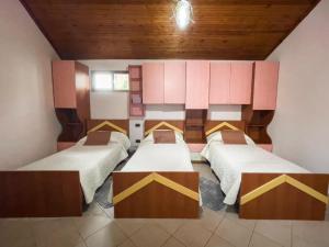 a room with three beds in a room at Vila Kodra in Tirana