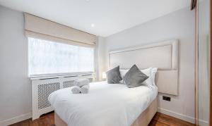 a bedroom with a large white bed with a window at Flat 2 in London