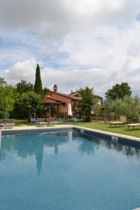 a large swimming pool in front of a house at Cortona Gabolina e Turata Holiday Home in Cortona