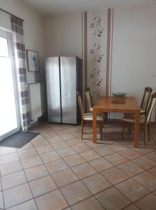 uma cozinha com uma mesa e um frigorífico de aço inoxidável em Gästehaus Atrico Haus 7 em Neubörger