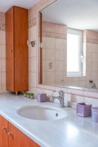 y baño con lavabo y espejo. en Mosaic art garden house, en Kokkíni Khánion