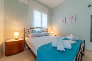 1 dormitorio con 1 cama grande con sábanas y almohadas azules en Mosaic art garden house en Kokkíni Khánion