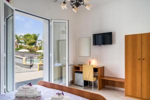 a bedroom with a desk and a computer in a room at Affittacamere villa Antonio in Aci Castello