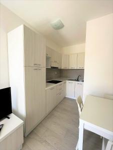 a kitchen with white cabinets and a white table at Affittimoderni La Maddalena - MADA25 in La Maddalena