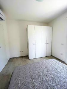 una habitación vacía con armarios blancos y una alfombra en Affittimoderni La Maddalena - MADA25 en La Maddalena