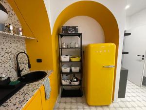 a yellow refrigerator in a kitchen with a yellow wall at Dusmè in Taranto