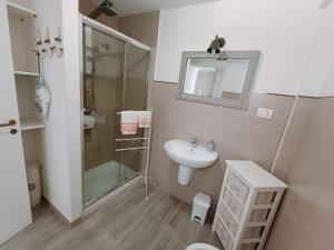 a bathroom with a glass shower and a sink at CasaCalò in Gallipoli