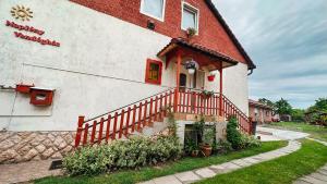 Napfény vendégház في جيور: منزل ذو مبنى احمر وبيض مع درج