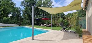 a yellow umbrella sitting next to a swimming pool at Bienvenue à L'ÉCRIN avec piscine privée in L'Isle-sur-la-Sorgue