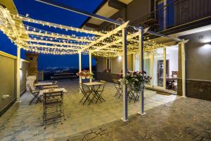 a patio with lights and tables and chairs on a building at Affittacamere villa Antonio in Aci Castello