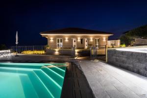 een huis met een zwembad in de nacht bij Affittacamere villa Antonio in Aci Castello