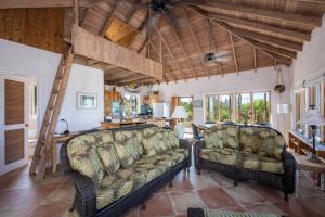 una sala de estar con 2 sofás y una escalera en Chez Cay Cottage cottage, en Governorʼs Harbour