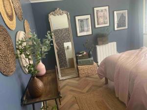 Dormitorio con espejo y mesa con cama en la planque d'hugo, en Jumièges