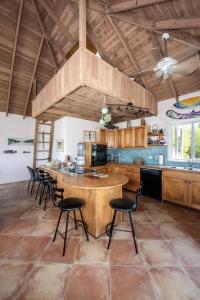 uma cozinha com uma grande ilha com cadeiras pretas em Chez Cay Cottage cottage em Governorʼs Harbour