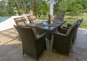- Mesa de comedor con sillas de mimbre en el patio en Casa Anajade, en Vara Blanca