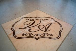 a sign on a tile floor with the initials psi at Affittacamere villa Antonio in Aci Castello