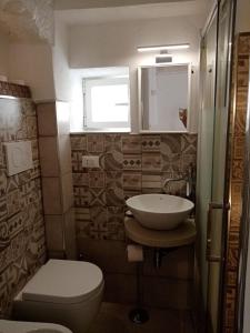 une salle de bain avec un lavabo et des toilettes et une fenêtre dans l'établissement Studio Flat in White City, à Ostuni
