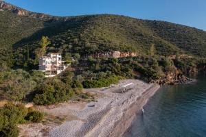 a house on a hill next to a body of water at Nikole's Villas Luxury 180m2 in Tiros