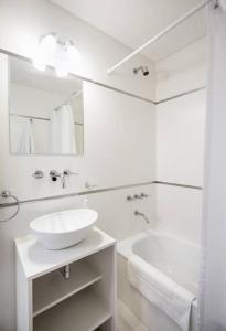Baño blanco con lavabo y bañera en Baires Homes - Belgrano en Buenos Aires
