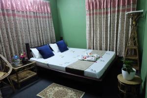 加德滿都的住宿－Sambodhi Yoga Home，一间卧室配有一张带蓝色枕头的床