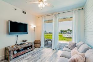 a living room with a couch and a tv at Harbor Cove #111 in Orange Beach