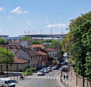 a city with cars parked on a street and a bridge at Résidence Du Grand Stade in Saint-Denis