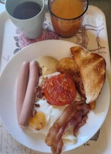 - un plateau de petit-déjeuner composé d'œufs à la saucisse, de bacon et de pain grillé dans l'établissement ArtMotel & Bistro, à Haţeg