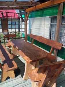 a wooden picnic table and chairs on a porch at Domek holenderski in Sztynort