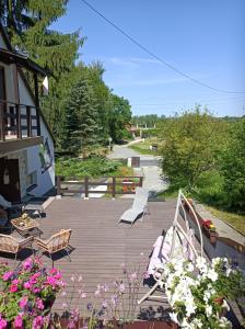 a wooden deck with chairs and flowers on it at Apartament u Izy in Kazimierz Dolny