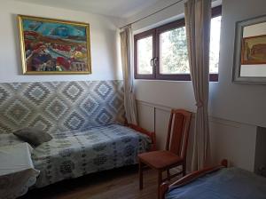 a bedroom with a bed and a chair and a window at Apartament u Izy in Kazimierz Dolny