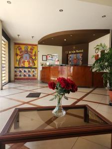 een lobby met een vaas rozen op een glazen tafel bij Hotel El Brujo Centro Histórico in Trujillo