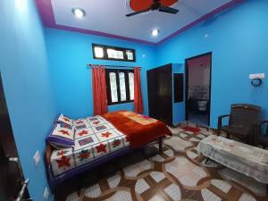 a bedroom with a bed and a blue wall at Somesh Homestay in Uttarkāshi
