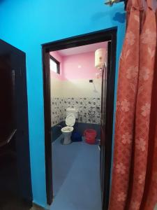 a bathroom with a toilet in a room with blue walls at Somesh Homestay in Uttarkāshi