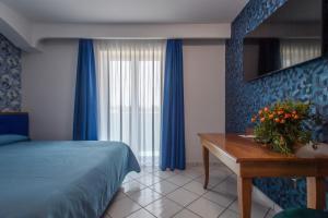 1 dormitorio con cama, mesa y ventana en Hotel Ancora en Pontecagnano