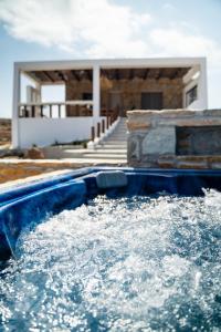 a pool of water with a house in the background at Saint Nicholas Resort - Villas in Kithnos