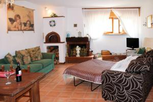 a living room with a green couch and a fireplace at Apartment at Villa Lorenzo in Villa Collemandina