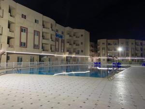 a large building with a swimming pool at night at سيرينا العلمين عائلات ممنوع الجروبات والميكسات in Abū Shunaynah