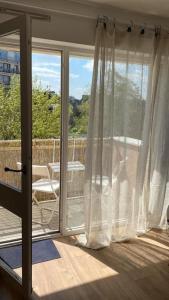 eine Glasschiebetür zu einem Balkon mit einem Tisch in der Unterkunft Appartement cosy Le Saint Gildas, à proximité immédiate centre ville, place de stationnement, Netflix in Vannes