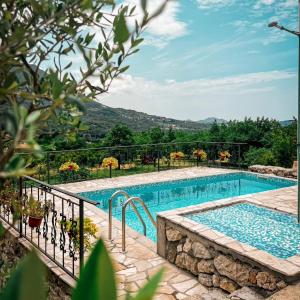 a large swimming pool next to a stone wall at Apartmani Dumezic in Bar