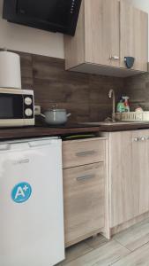 una cucina con armadi in legno e forno a microonde di Pokoje przy lesie a Stegna