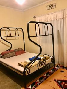 ein Bett mit zwei Metalletagenbetten in einem Zimmer in der Unterkunft Nomads nest safari house in Arusha