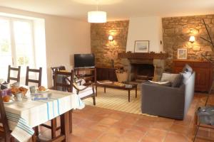 ein Wohnzimmer mit einem Tisch und einem Kamin in der Unterkunft Crac’h, grande maison de vacances au calme in Crach
