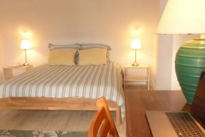 Schlafzimmer mit einem Bett und einem Schreibtisch mit einem Laptop in der Unterkunft Crac’h, grande maison de vacances au calme in Crach