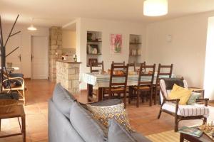 un salon avec un canapé, une table et des chaises dans l'établissement Crac’h, grande maison de vacances au calme, à Crach