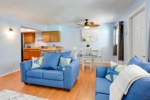 a living room with a blue couch and a kitchen at Idyllic Fort Pierce Retreat - Walk to Beach! in Fort Pierce +17 photos