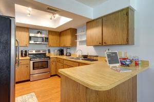 cocina con armarios de madera y encimera en Idyllic Fort Pierce Retreat - Walk to Beach!, en Fort Pierce