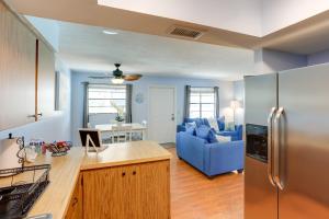 a kitchen with a refrigerator and a blue couch at Idyllic Fort Pierce Retreat - Walk to Beach! in Fort Pierce